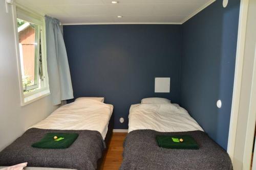 2 camas en una habitación con paredes azules en Cottage for visiting sea, city, forest en Holm
