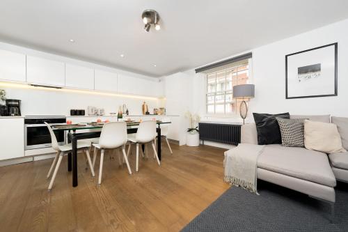 a living room with a couch and a table and chairs at Aircon 2 Bedr, 3 Beds, 2 Bath Covent Garden, Subway in London