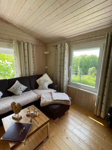 a living room with a couch and a window at Bergchalet Löwenzahn in Benshausen