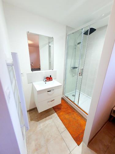 une salle de bain blanche avec une douche et un lavabo dans l'établissement Cocon Méditerranéen à 15 minutes des plages, à Maraussan
