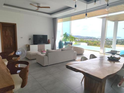 a living room with a couch and a table at Villa Gratia Alba in Amphoe Koh Samui