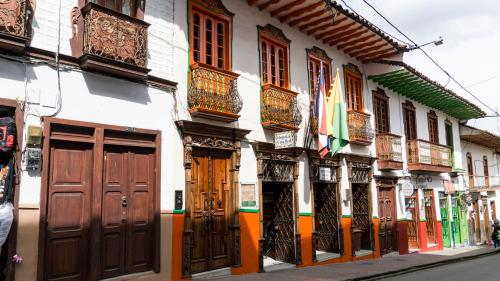 una fila de edificios con puertas y ventanas de madera en Hospedaje Casa Real en Salamina