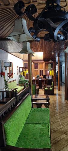 a living room with green couches and tables at Hospedaje Casa Real in Salamina