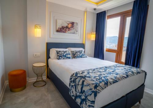 um quarto com uma cama azul e branca e uma janela em Shah Residence Hotel em Bostancı