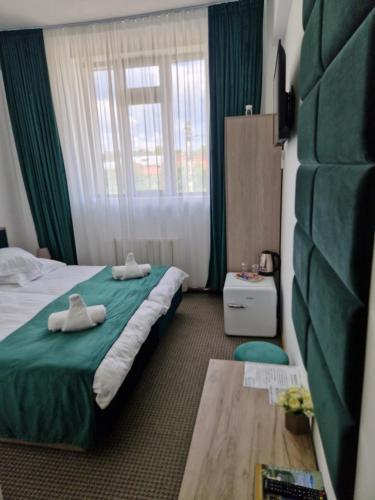 a hotel room with a bed with towels on it at ANTIK HOUSE in Cornu de Jos