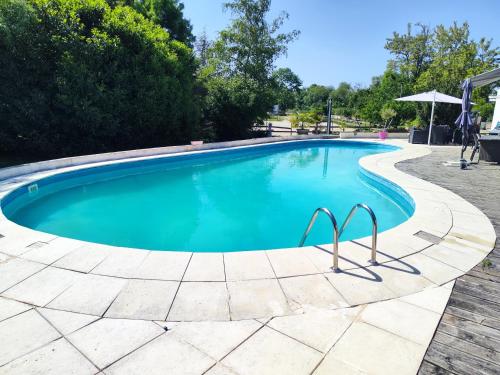 a large swimming pool with blue water at Gîte du Moulin de Tart le Bas 