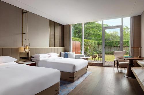 a hotel room with two beds and a patio at Midea Shunde, a Tribute Portfolio Hotel in Shunde