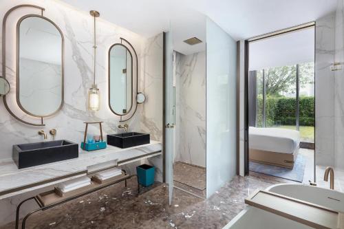 a bathroom with two sinks and a mirror at Midea Shunde, a Tribute Portfolio Hotel in Shunde