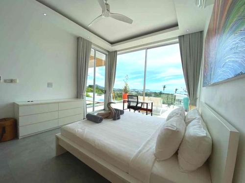 1 dormitorio con 1 cama grande y ventana grande en Villa Gratia Alba en Nathon Bay