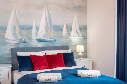 a bedroom with a bed with sailboats painted on the wall at Apartament Kapitański Centrum Łeba in Łeba
