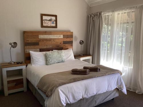 a bedroom with a large bed and a window at Ledges Retreat in Bergville