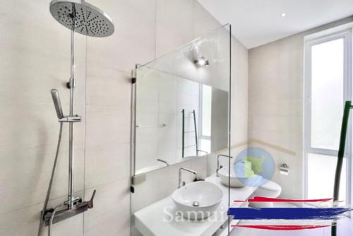 a bathroom with a glass shower and a sink at Villa Gratia Alba in Amphoe Koh Samui