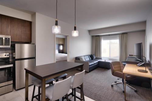 a kitchen and living room with a table and chairs at Residence Inn by Marriott La Quinta in La Quinta