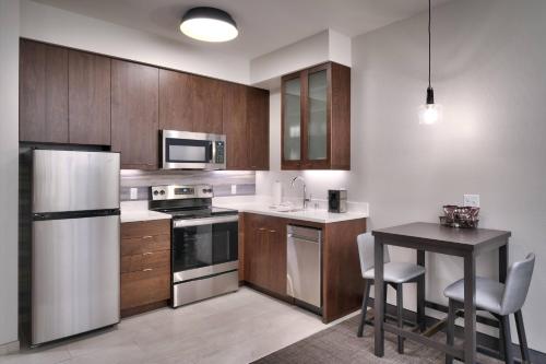 a kitchen with a refrigerator and a table with chairs at Residence Inn by Marriott La Quinta in La Quinta