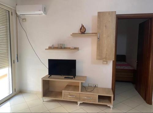 uma sala de estar com uma televisão num suporte de madeira em Martin Apartment em Vlorë