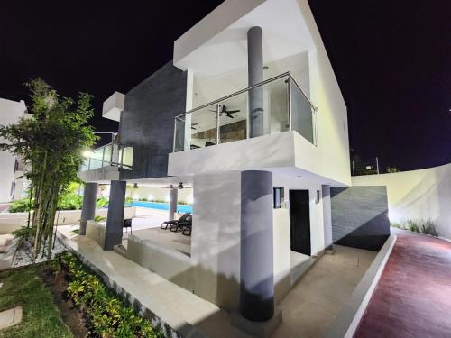 a white house with a pool at night at Astoria Gated Condos in Cancún