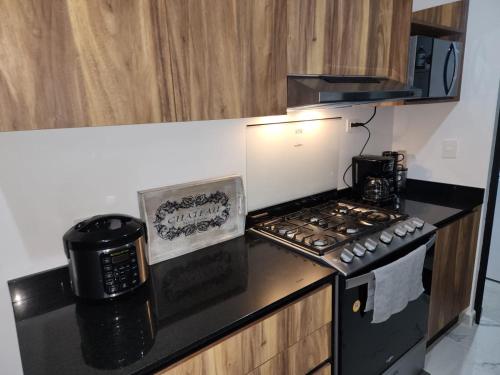 a kitchen with a stove and a microwave at Astoria Gated Condos in Cancún