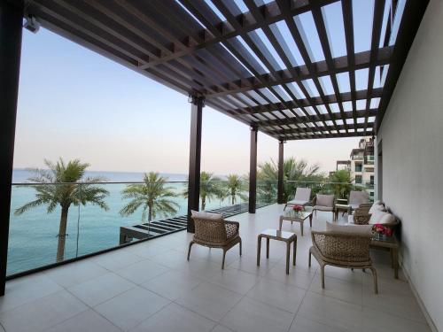 a patio with chairs and a view of the ocean at Three Bedrooms Apartment at Address Residence Fujairah - AFR3203 in Fujairah