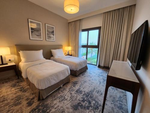 a hotel room with two beds and a flat screen tv at Three Bedrooms Apartment at Address Residence Fujairah - AFR3203 in Fujairah