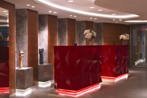 a red podium in a lobby with flowers on it at Renaissance Paris Republique Hotel & Spa in Paris