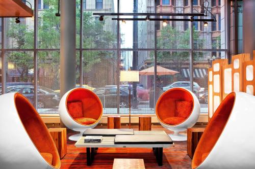 a room with three chairs and a table and a window at Aloft Chicago Downtown River North in Chicago