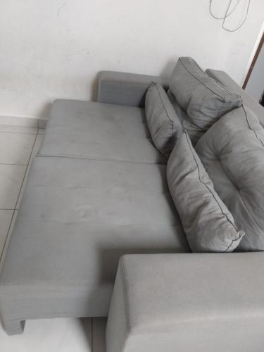 um sofá cinzento com duas almofadas num quarto em Apartamento temporada para São joao em Campina Grande