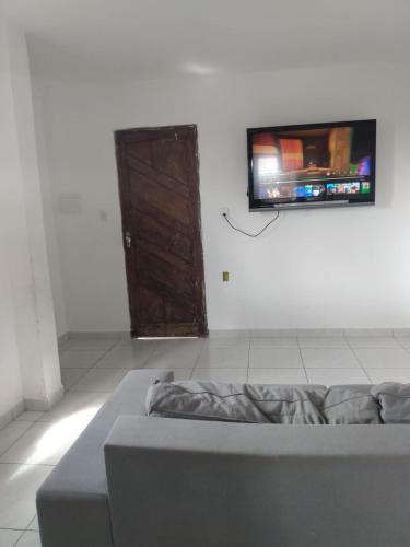 Habitación con cama y TV en la pared. en Apartamento temporada para São joao, en Campina Grande