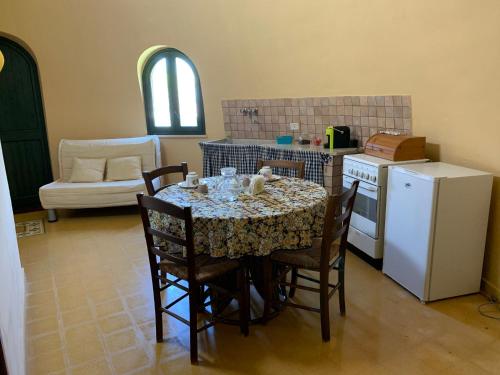 uma cozinha com uma mesa com cadeiras e um frigorífico em S&S - Marino's Resort em Petrosino