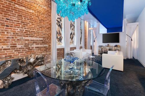a dining room with a glass table and a brick wall at The Saint Hotel, New Orleans, French Quarter, Autograph Collection in New Orleans