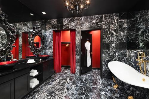 a bathroom with red and black walls and a tub at The Saint Hotel, New Orleans, French Quarter, Autograph Collection in New Orleans
