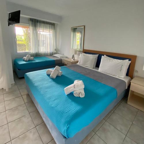 a hotel room with two beds with towels on them at Pansion Argo in Nea Moudania
