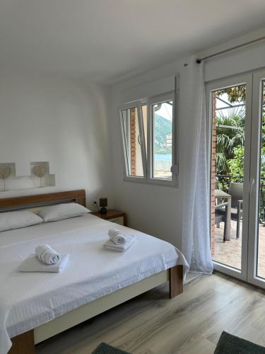 Dormitorio blanco con cama y puerta corredera de cristal en Sea Level, en Risan