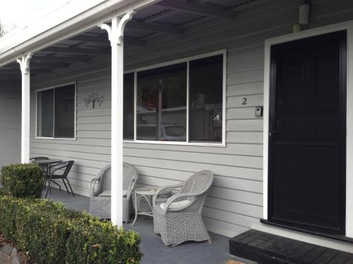 a porch with two chairs and a table and windows at Phillip Island Cottages in Cowes