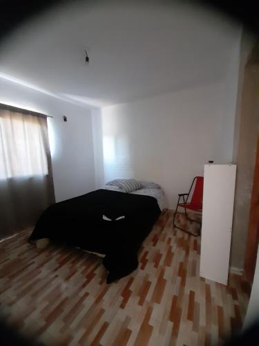 um quarto com uma cama e piso em madeira em Casa ROCIO em Chimbas