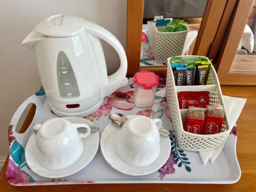 a tea set on a tray with a tea kettle and cups at Seaside Rooms Gorleston in Gorleston-on-Sea