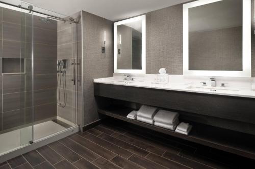 a bathroom with two sinks and a shower at Warner Center Marriott Woodland Hills in Woodland Hills