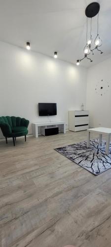 a living room with a couch and a tv on a wall at Apartament CityStation in Wałbrzych