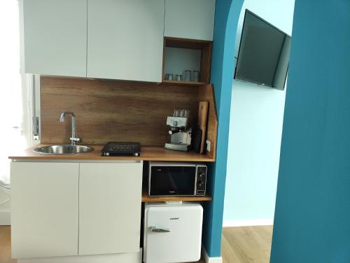 a small kitchen with a microwave and a sink at B&B LIBRA rooms & suite in Salerno