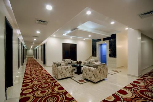 a lobby with two chairs and a table and a rug at Best Western Swing High Katra in Katra