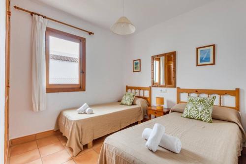 Zimmer mit 2 Betten und einem Fenster in der Unterkunft Villa Mar. En Ciudadela Menorca in Cala'n Bosch