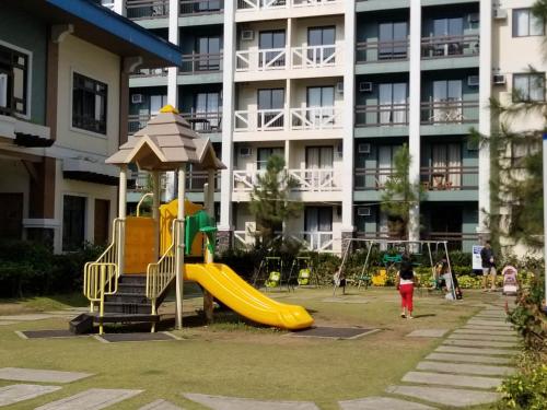 a playground with a slide in front of a building at Family Group Affordable Staycation in tagaytay in Tagaytay