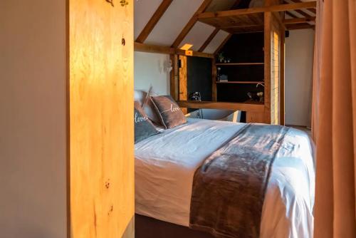 a bedroom with a large bed in a room at La vie en Rose - Pet friendly Tiny house in the nature with fenced garden in Torhout
