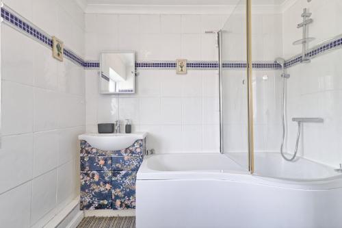 ein weißes Badezimmer mit einer Badewanne und einem Waschbecken in der Unterkunft Elegant 3 Bedroom House in Basildon - Essex Free Parking & Superfast Wifi, upto 6 Guests in Basildon
