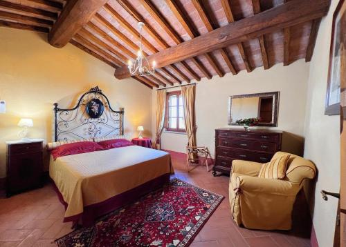 een slaapkamer met een bed en een stoel in een kamer bij Agriturismo Cima alla Serra in Buti