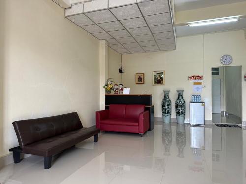 - un salon avec un canapé et un fauteuil rouge dans l'établissement Thong Sai Homstay BETONG -ทองใสโฮมสเตย์-, à Betong