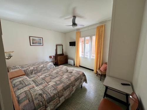 a hotel room with a bed and a window at Hostal Zurich in Sant Feliu de Guixols