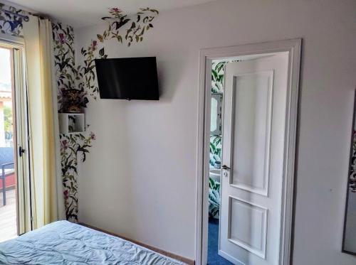 - une chambre avec un lit et une télévision murale dans l'établissement Casa vacanze Isolotto, à Isola delle Femmine