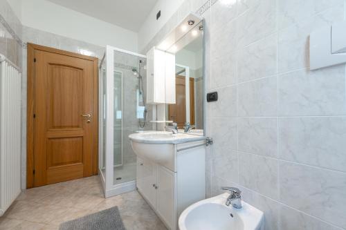 a bathroom with a sink and a toilet and a mirror at Nonna Elvira Holiday House in Bondone