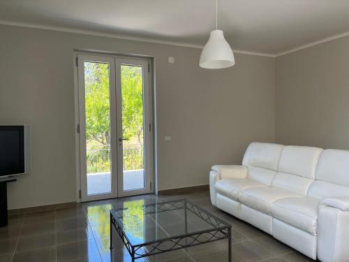 a living room with a white couch and a glass coffee table at Villa Claudia - casa vacanze in Agropoli