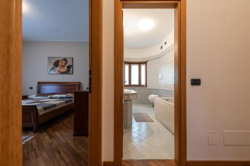 um quarto com uma cama e uma casa de banho com uma banheira em Nonna Elvira Holiday House em Bondone